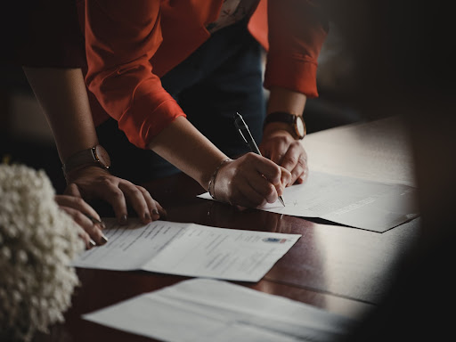 personne signant un document, optez pour la dématérialisation afin de réduire les risques de perte et de gagner du temps.