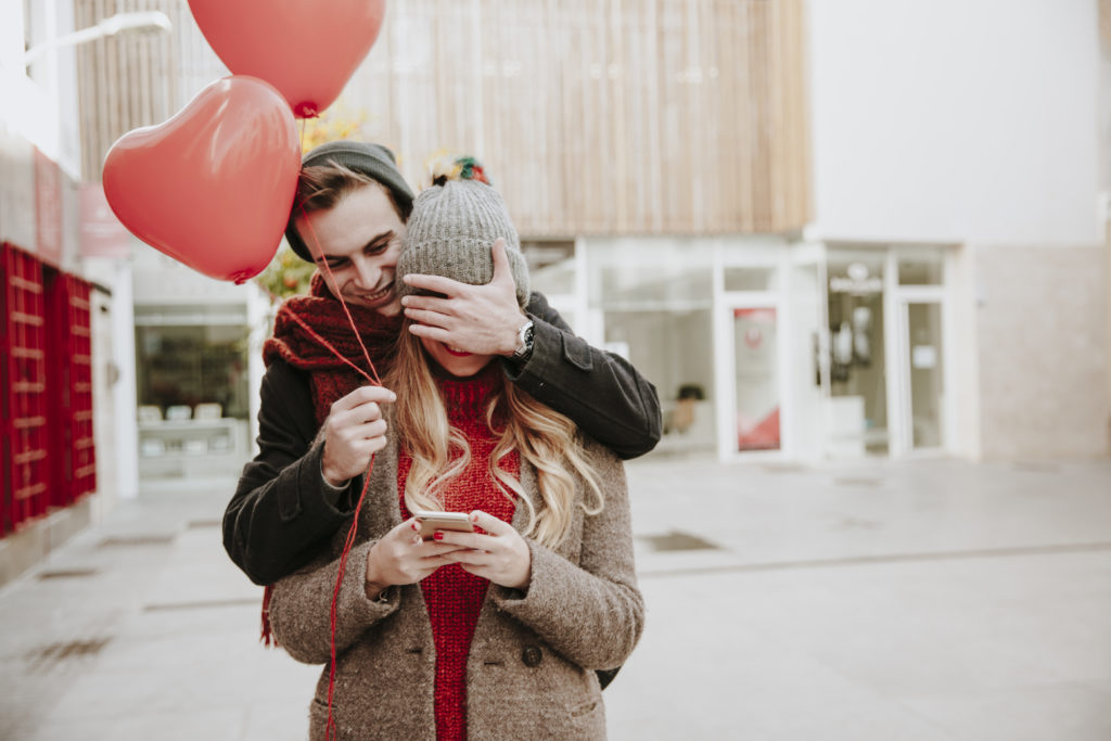 couple en excursion pour la saint valentin avec des ballons en forme de coeur rouge  