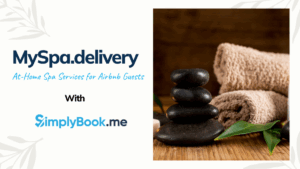Tranquil spa scene with stacked smooth black stones, a neatly rolled brown towel, and fresh green leaves, representing MySpa.delivery booking through SimplyBook.me
