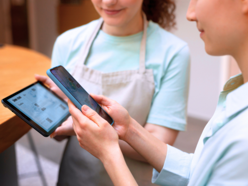 Collaborative scene with tablet and phone, SimplyBook.me mobile app setting SMB trends and meeting client expectations.