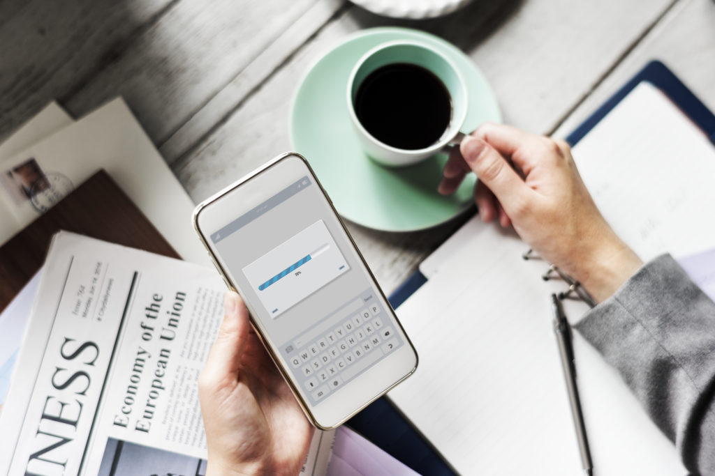 Busy professional holding phone with loading screen, showcasing SimplyBook.me mobile app and booking habits.