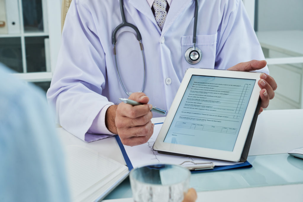 Doctor on a tablet using HIPAA-Compliant Scheduling Software to manage medical appointment booking and review PHI