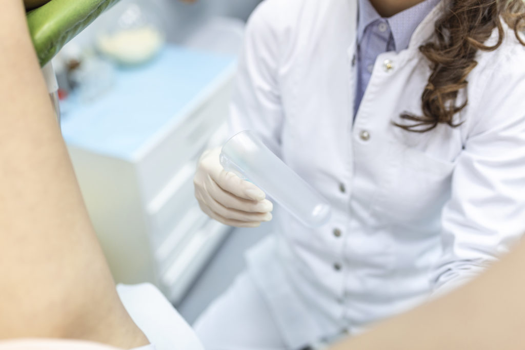 Medical professional in white coat holding device in clinic. 