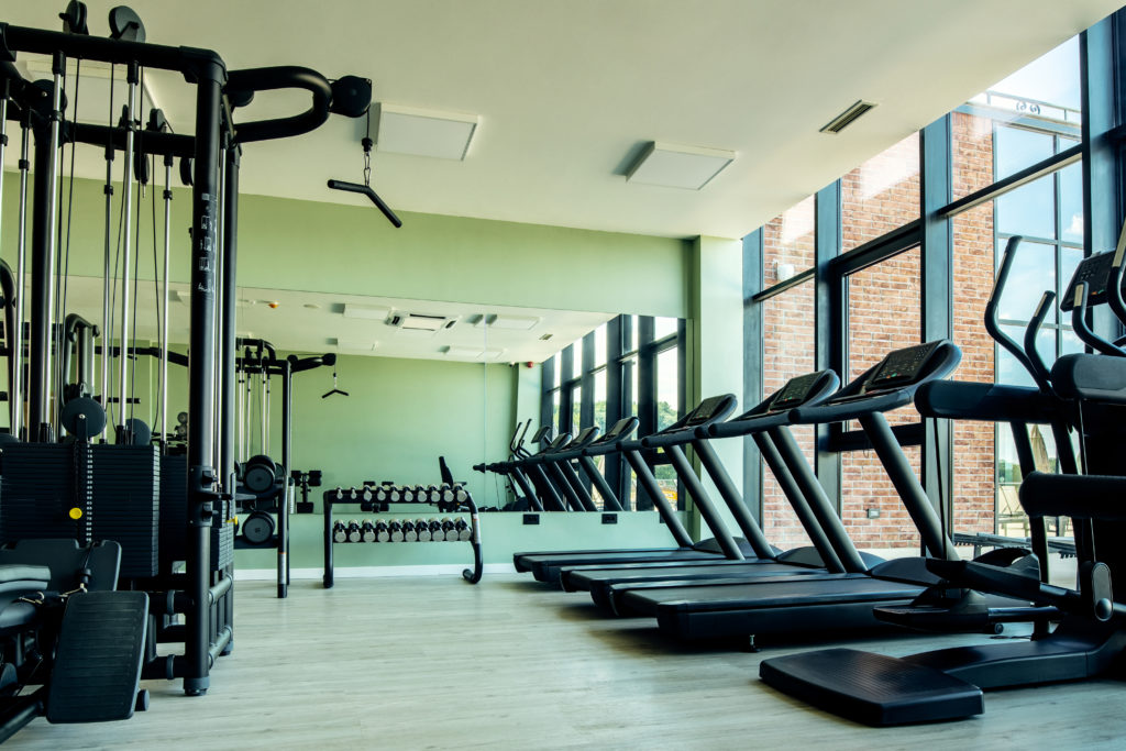 Modern gym with treadmills and weights using gym membership management tools for client retention.