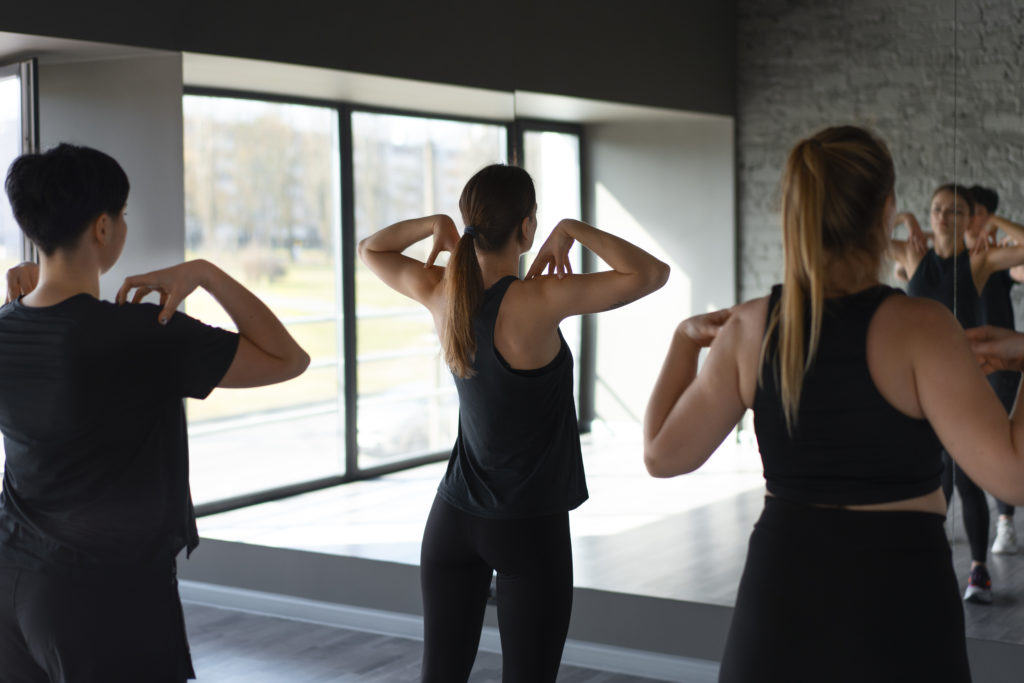 Gym members stretching together in a bright studio.