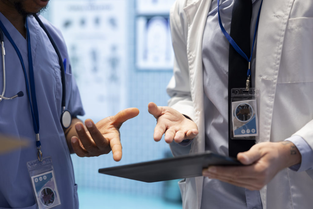 Two healthcare professionals using a tablet. Medical appointment scheduling software improves patient care.