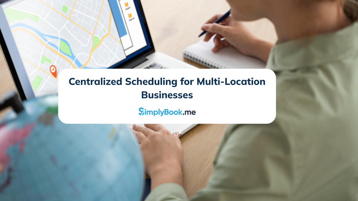 A person taking notes sits at a desk with a laptop displaying a map. The text reads, "Centralized Scheduling for Multi-Location Businesses." A globe is visible.